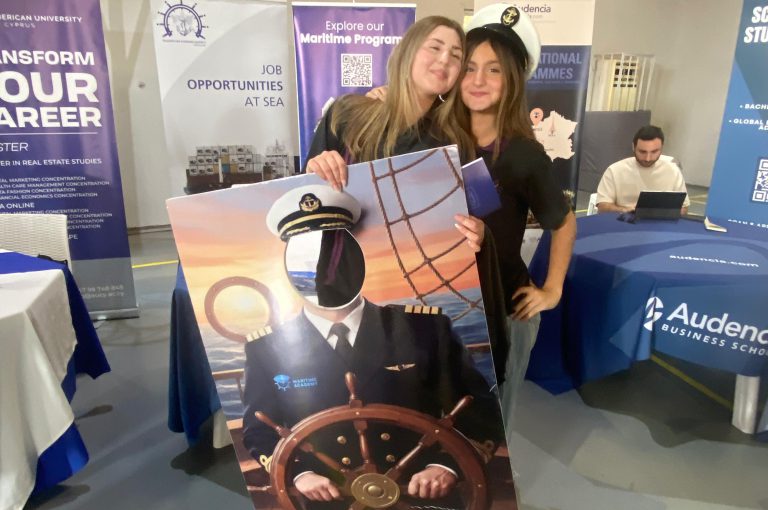 High school students in Grades 10–-12 visiting a university fair, exploring booths and talking to representatives.