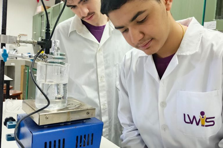 IB Year 1 students performing a lab experiment to find the molar mass of a volatile liquid