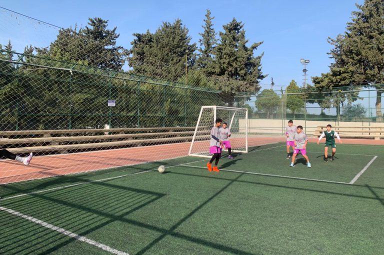 LWIS-AiS students playing football against St Jean Okaibe at the Lebanese Schools Tournament at NDU Zouk Mosbeh, showing teamwork and determination."