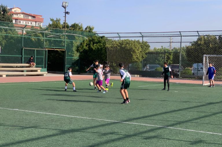 LWIS-AiS students playing football against St Jean Okaibe at the Lebanese Schools Tournament at NDU Zouk Mosbeh, showing teamwork and determination."