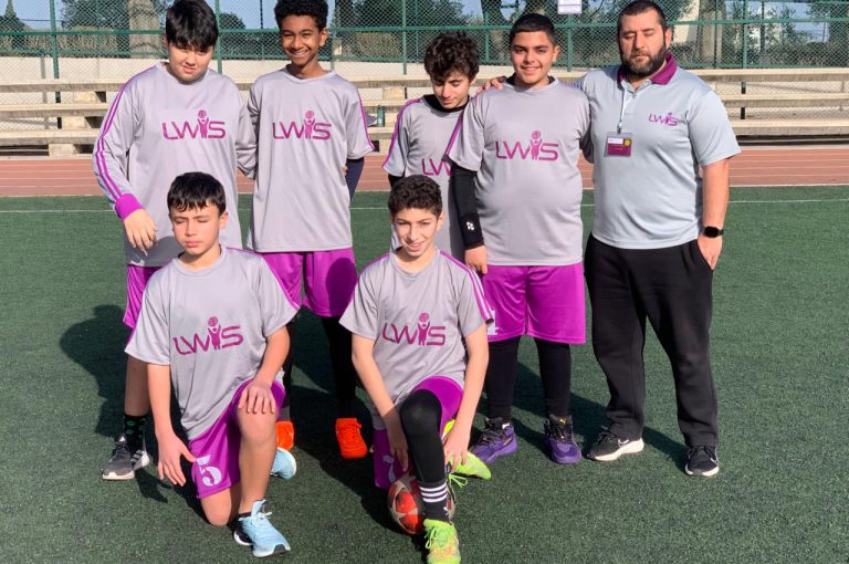 LWIS-AiS students playing football against St Jean Okaibe at the Lebanese Schools Tournament at NDU Zouk Mosbeh, showing teamwork and determination."