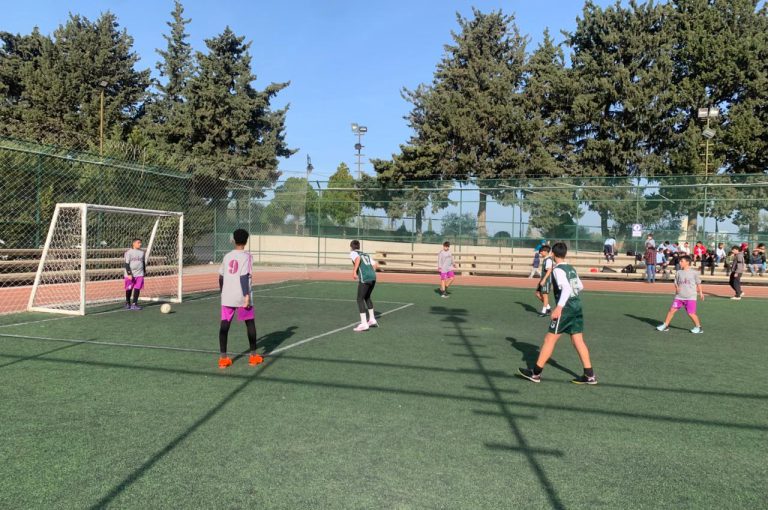 LWIS-AiS students playing football against St Jean Okaibe at the Lebanese Schools Tournament at NDU Zouk Mosbeh, showing teamwork and determination."