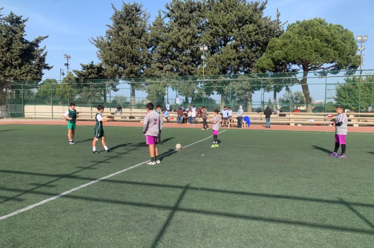 LWIS-AiS students playing football against St Jean Okaibe at the Lebanese Schools Tournament at NDU Zouk Mosbeh, showing teamwork and determination."