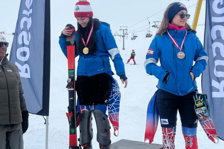 Leona on the podium after winning second place in the junior category at the Lebanese Alpine Ski Championship, wearing ski gear and holding her medal.