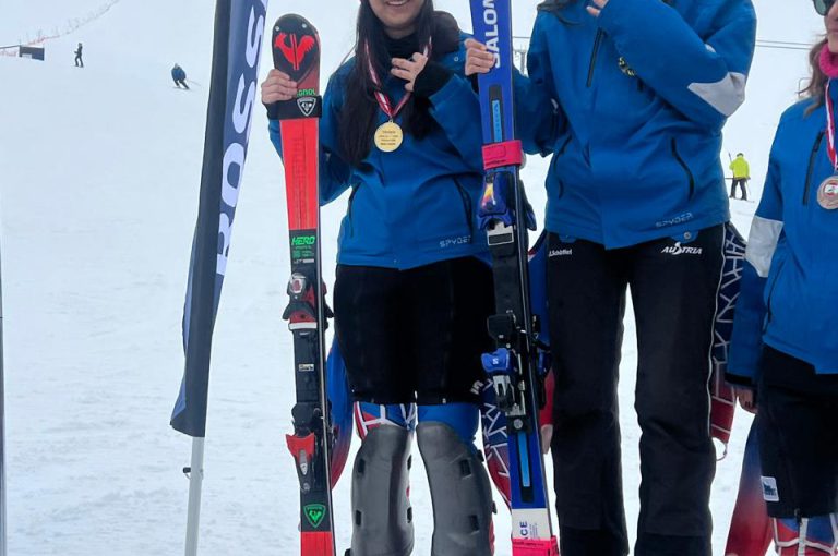 Leona on the podium after winning second place in the junior category at the Lebanese Alpine Ski Championship, wearing ski gear and holding her medal.