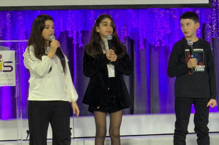 LWIS AIS students standing on stage, reciting poetry during Poetry Night event.