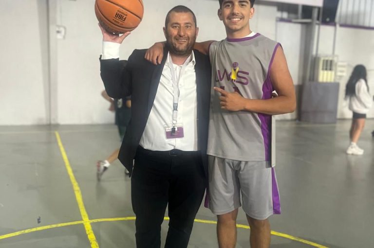 Team huddle showing unity, determination, and school spirit before winning the Round of 16 basketball match and qualifying for the Quarter Finals of the Lebanese School Basketball Championship.